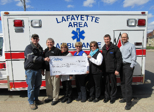 Lafayette staff presents a check to the Lafayette Area Ambulance for their new hydraulic lift cot.